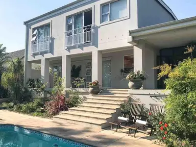 a house with a swimming pool in front of it at Lavender Suite in Cape Town