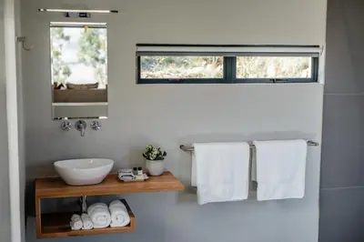 a bathroom with a sink and a mirror and towels at Opstal Stay in Rawsonville