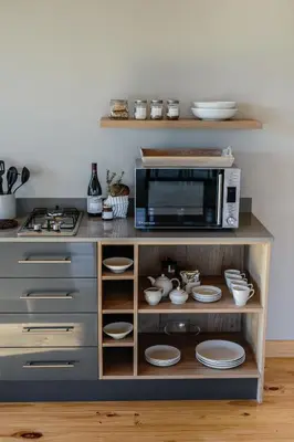 a kitchen with a microwave and plates on a shelf at Opstal Stay in Rawsonville