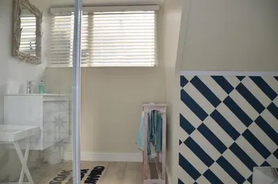 a bathroom with a shower and a sink at Beach Cottage 1 in Hermanus