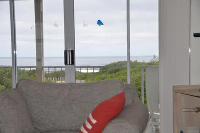 a living room with a couch and a view of the ocean at Beach Cottage 2 in Hermanus