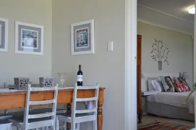 a room with a table and two chairs and a bed at Beach Villa Apartment in Hermanus