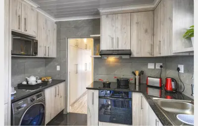 a kitchen with wooden cabinets and a stove top oven at 9a@Crassula Way in Cape Town