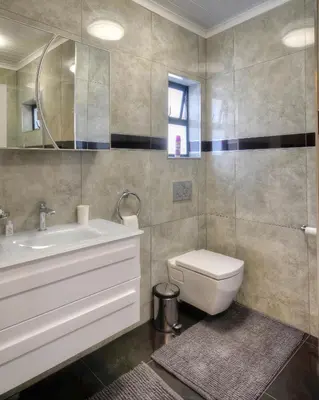 a bathroom with a sink and a toilet and a mirror at 9a@Crassula Way in Cape Town