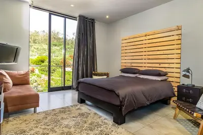 a bedroom with a large bed and a large window at Stellar Guest Villa on Stunning Wine Farm in Cape Town