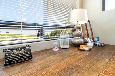 a room with a lamp and a bird cage and a window at Stellar Guest Villa on Stunning Wine Farm in Cape Town