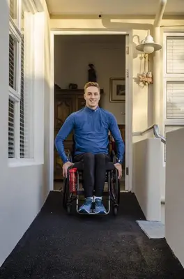 a man in a wheelchair sitting in a doorway at Somerset View Guest House in Somerset West