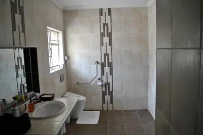 a bathroom with a toilet and a sink and a shower at Cotswold House Residence in Cape Town