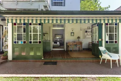 a house with green doors and a dining room at Sandown Lodge in Cape Town