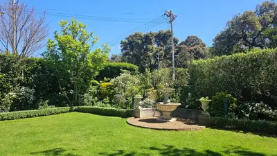 a garden with a fountain in the middle of a yard at Sandown Lodge in Cape Town