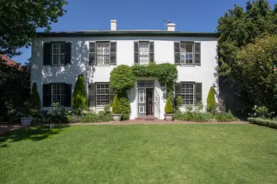 a white house with a door and a yard at Sandown Lodge in Cape Town
