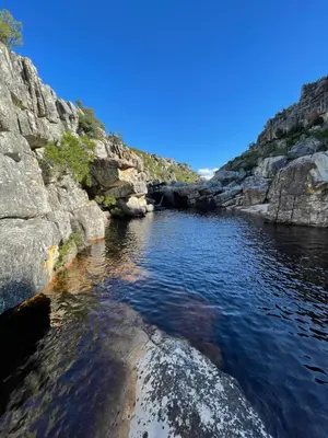 a body of water with rocks and blue sky at McBains in Breerivier