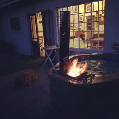 a fireplace in a living room with a dog laying next to it at McBains in Breerivier