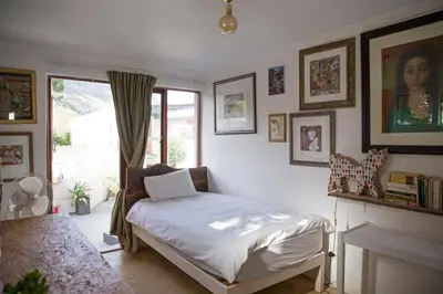 a bedroom with a bed in a room with a fireplace at McBains in Breerivier