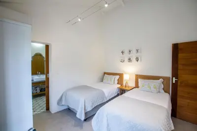 a bedroom with two beds and a sink at Denneboom Vineyards and Wildlife in Paarl