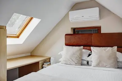 a bedroom with a bed and a window and a ceiling at Le Arc Manor House in Franschhoek