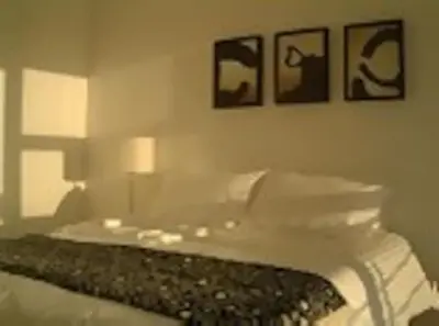 a bedroom with a bed with two pictures on the wall at WhiteSands in Cape Town