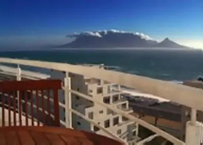 a balcony with a view of the ocean and a mountain at WhiteSands in Cape Town