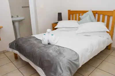 a bed with two stuffed animals sitting on it at Helderzicht Self-Catering in Brackenfell