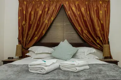 a bedroom with a bed with towels on it at Helderzicht Self-Catering in Brackenfell