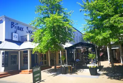 a street with shops and trees in front of a building at Franschhoek Studio in Franschhoek
