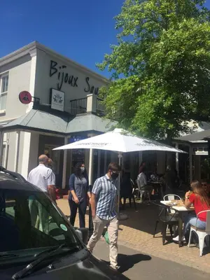 a man walking down a street under an umbrella at Franschhoek Studio in Franschhoek