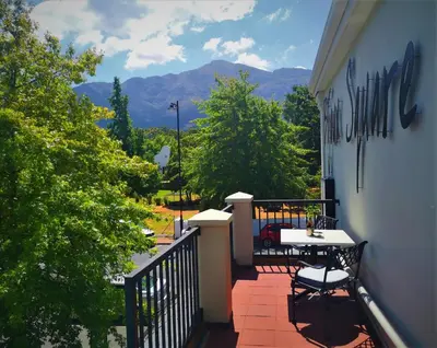 a balcony with a table and chairs on a building at Franschhoek Studio in Franschhoek
