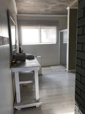 a room with a table in the middle of a room at The Vineyard East in Joostenberg Vlakte
