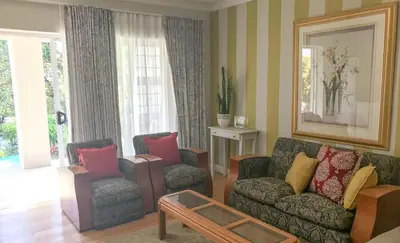 a living room with a couch and two chairs at Protea Suite in Cape Town