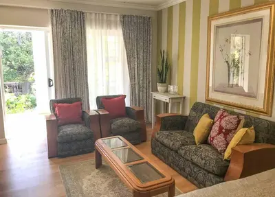 a living room with a couch and two chairs at Protea Suite in Cape Town