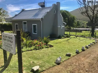 a small house with a sign in front of it at Kleine Vrede Farm Cottage in Hermanus