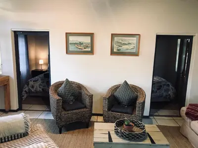 a living room with two chairs and a table at Kleine Vrede Farm Cottage in Hermanus