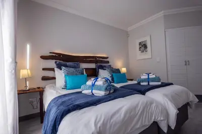 a bedroom with two beds with blue and white at Bem Vindo Self Catering Guest House in Hermanus
