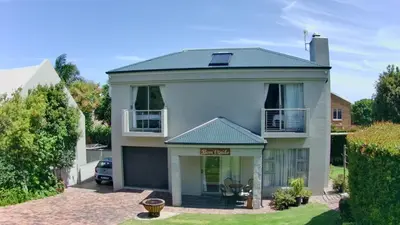 a white house with a green roof at Bem Vindo Self Catering Guest House in Hermanus
