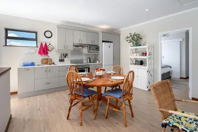 a kitchen and dining room with a table and chairs at Steenbok House in Hermanus