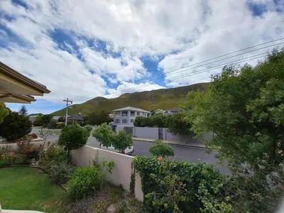 a view of a street with a house and a mountain at Steenbok House in Hermanus