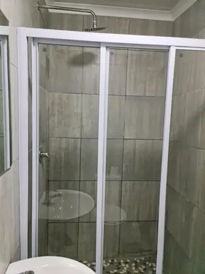 a shower with a glass door in a bathroom at Hasate Guest House 10 Florence street Oakdale Belliville 7530 cape town south African in Cape Town