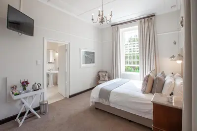 a white bedroom with a bed and a window at Elgin Vintners Country House in Elgin