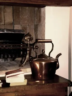 a tea kettle on a table next to a piano at MAVILLA STELLENBOSCH B&B in Stellenbosch
