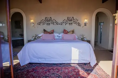 a bedroom with a large white bed with pink pillows at Casa Mori House in Stellenbosch
