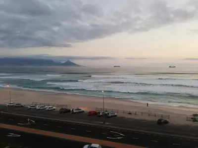 a view of a beach with cars parked on the sand at 504 Witsand in Bloubergstrand