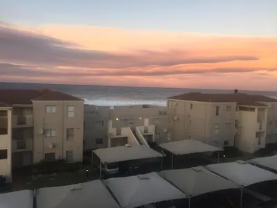 an aerial view of buildings and the ocean at sunset at Huisi by di C in Hermanus