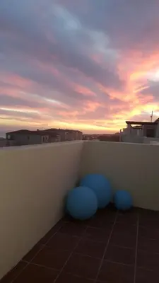 a balcony with blue balls on the side of a wall at Huisi by di C in Hermanus