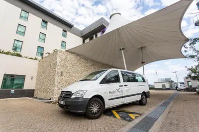a white van parked in front of a building at Hotel Verde Cape Town Airport in Matroosfontein