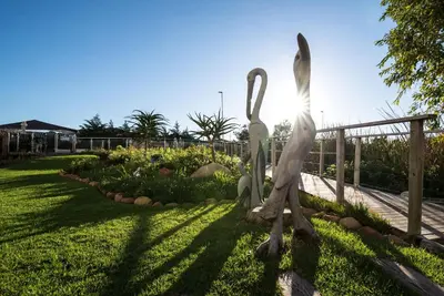 a statue of two swans in a garden at Hotel Verde Cape Town Airport in Matroosfontein