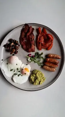 a plate of food with eggs sausage and other foods at Kianga in Gordonʼs Bay