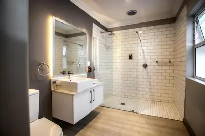 a bathroom with a white sink and a shower at Whale Coast Ocean Villa in Hermanus