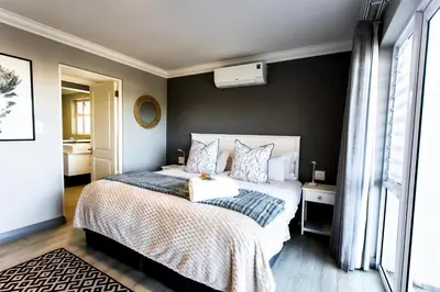 a bedroom with a bed and a black wall at Whale Coast Ocean Villa in Hermanus