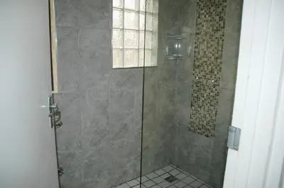 a bathroom with a shower with a glass door at Pelican Accommodation Ottery in Cape Town