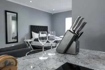 two wine glasses sitting on a counter in a living room at Milo's Sky Grey Guest House - No Load shedding in Cape Town
